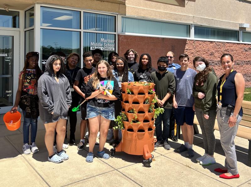 Gathered by the flower and herb planter at Mariner Middle School are in back (l-r) Za'Niyah Chandler, Dalton Brittingham, School Secretary Elaine Pleasanton, Lenny Herrera-Escobar, Sincere Pabon, Jason Kashner, Koran Wildy and School Resource Officer Cpl. Crysti Davis. In the middle are Selma Kingsberry, Steven Kapper, Nakiy'zha Smith, Valentin Cotoc-Ortiz, Austin Brown, Remi Bailey and Assistant Principal Emily Lehne. In front is Dakota Wise. SUBMITTED PHOTOS